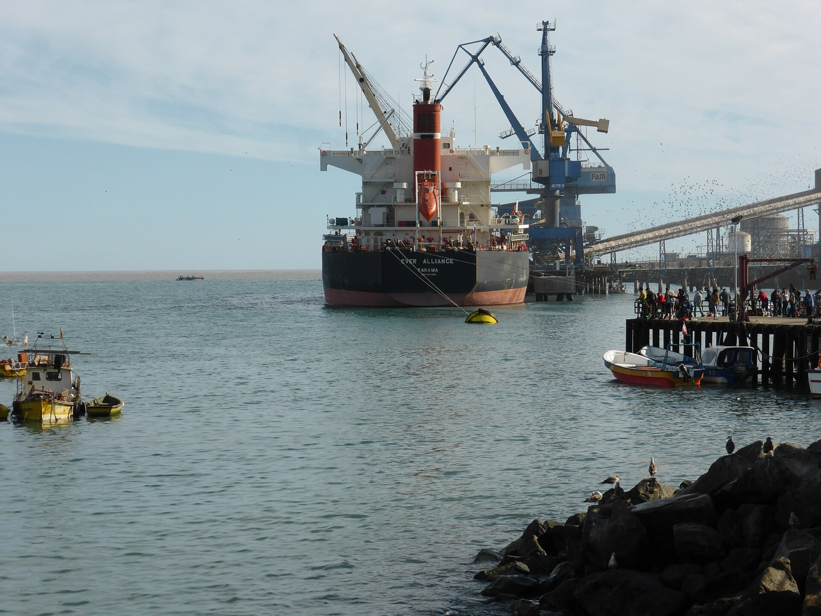Puerto de San Antonio: buque granelero atracado en el muelle junto a una grúa de carga y el espigón en primer plano